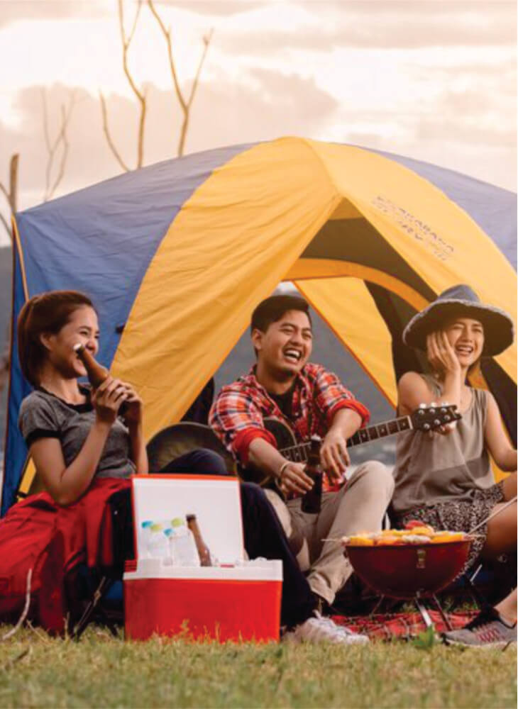 group of budget travelers sitting near yellow and blue tent in Masai Mara and having good time on affordable group safari tours