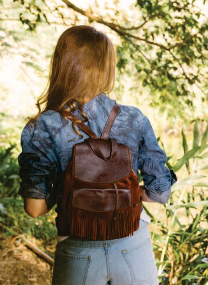 young woman with brown backpack walking away in Masai Mara on affordable safari to Serengeti and Masai Mara