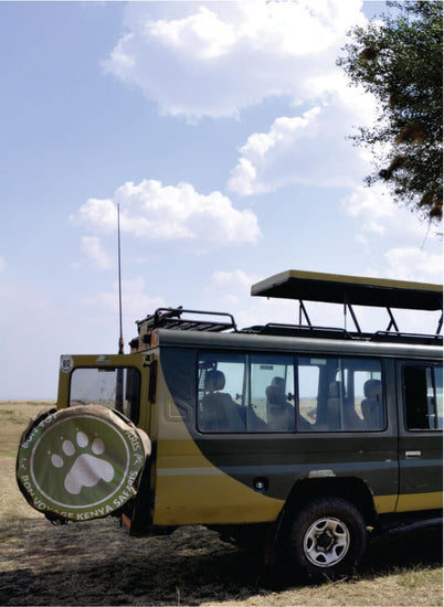 green 4x4 jeep with pop up top parked on green grass field with back door open in Masai Mara during 3-day Masai Mara tour