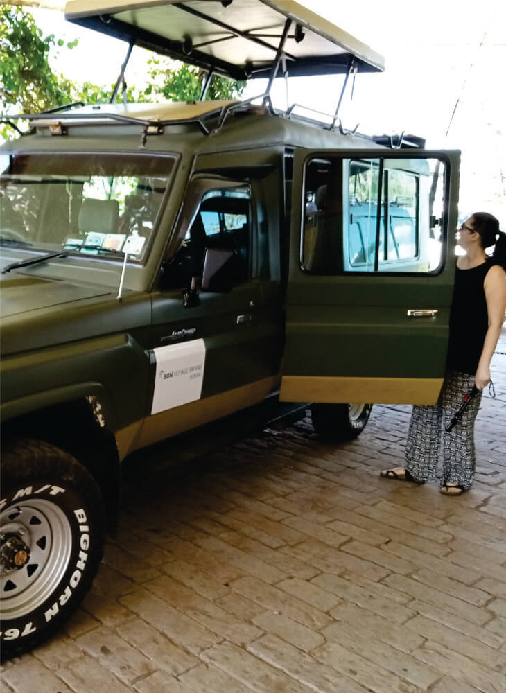 young woman boarding a green 4x4 jeep with pop-up top in Masai Mara during Masai Mara joining jeep safari tours